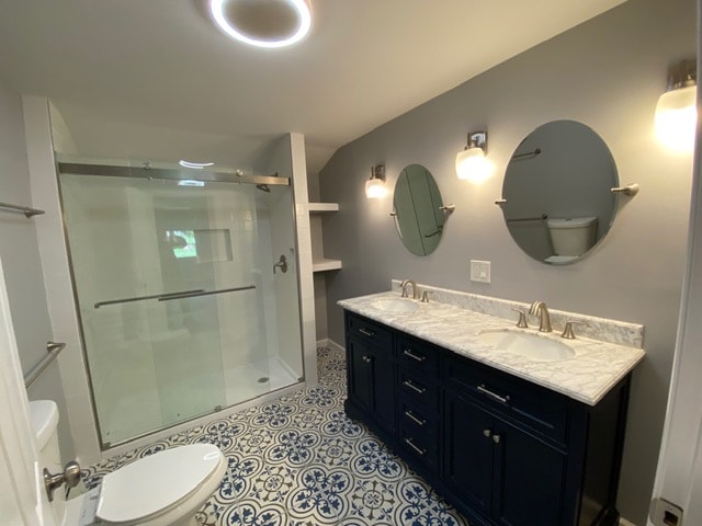 Completed bathroom renovation with dual-sink vanity, walk-in shower, and decorative tile flooring
